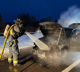 photo of a Greeley firefighter extinguishing an automobile fire